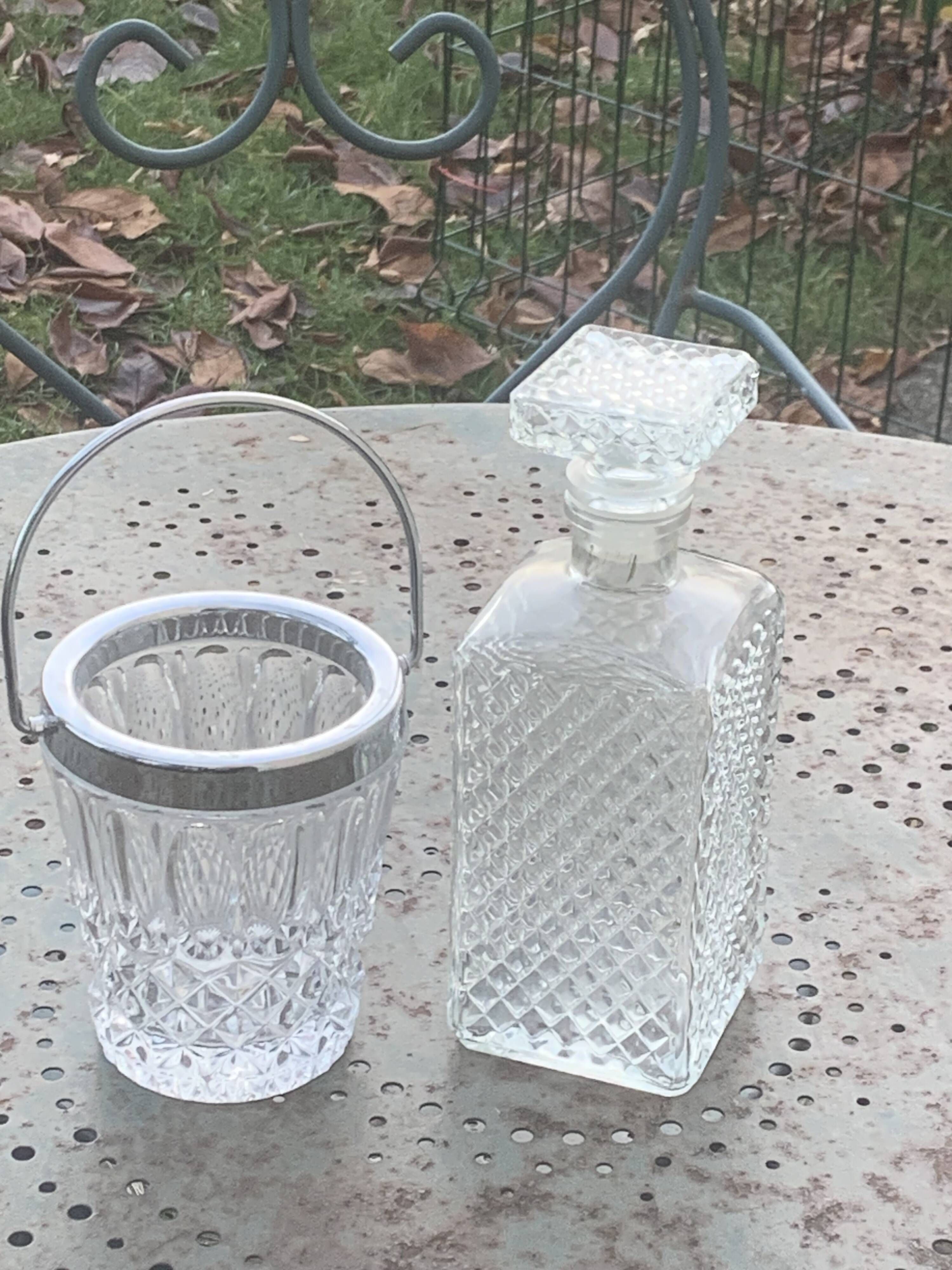 Whiskey carafe and ice bucket in transparent glass and silver-colored metal handle
