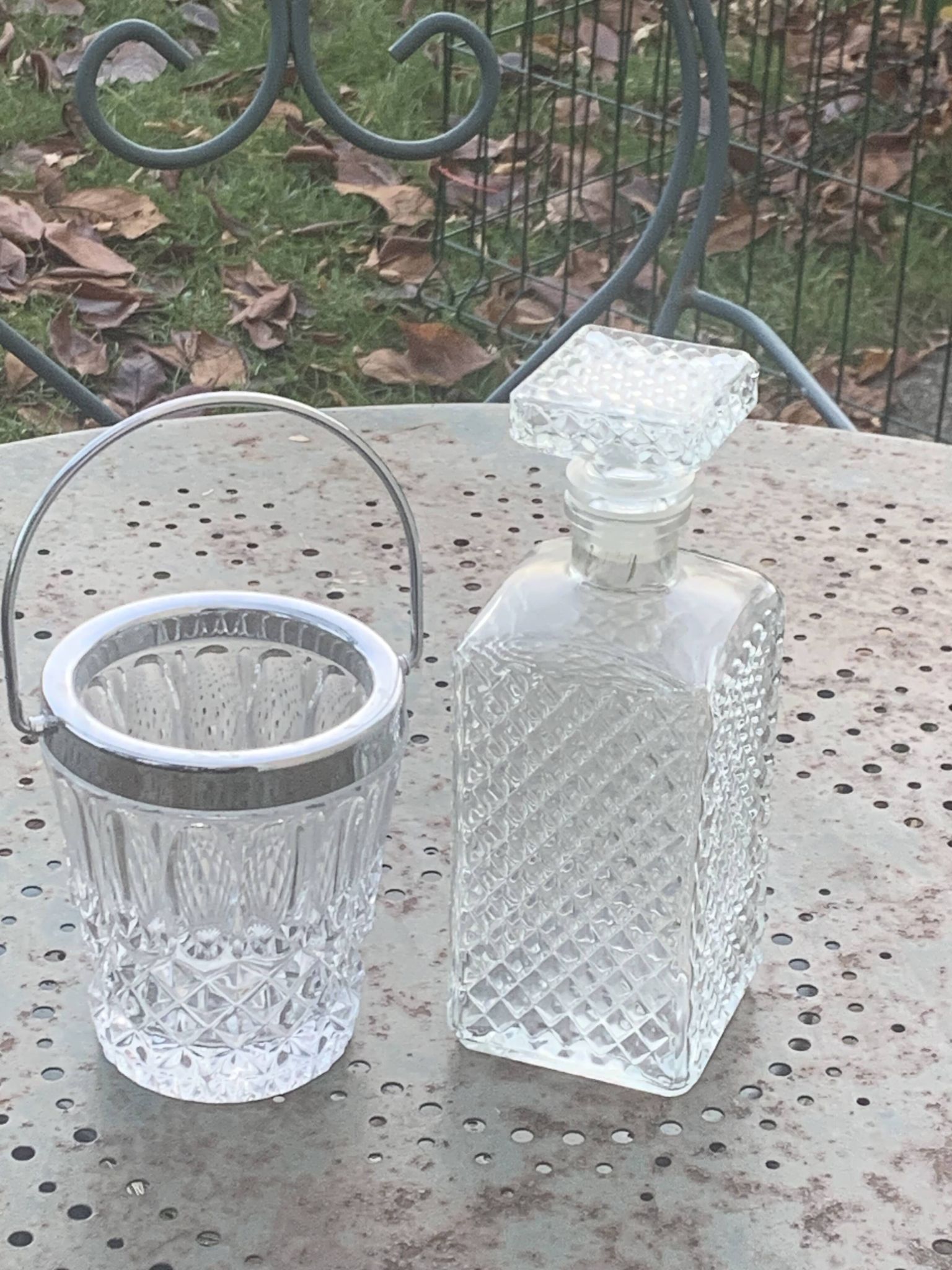 Whiskey carafe and ice bucket in transparent glass and silver-colored metal handle