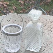 Whiskey carafe and ice bucket in transparent glass and silver-colored metal handle