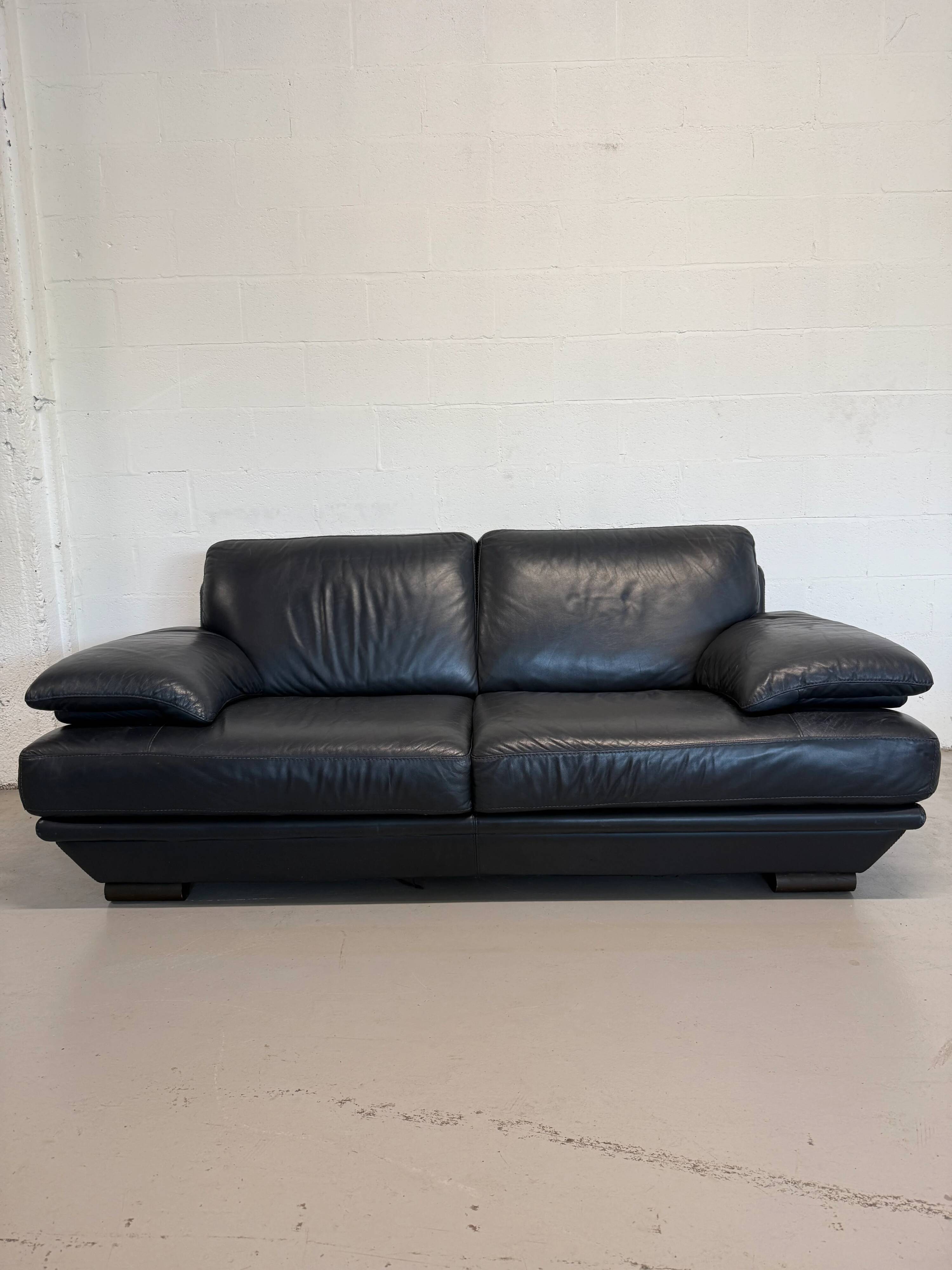Two-seater Natuzzi sofa in navy blue leather.