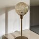 Table lamp with a golden striated globe and a golden base