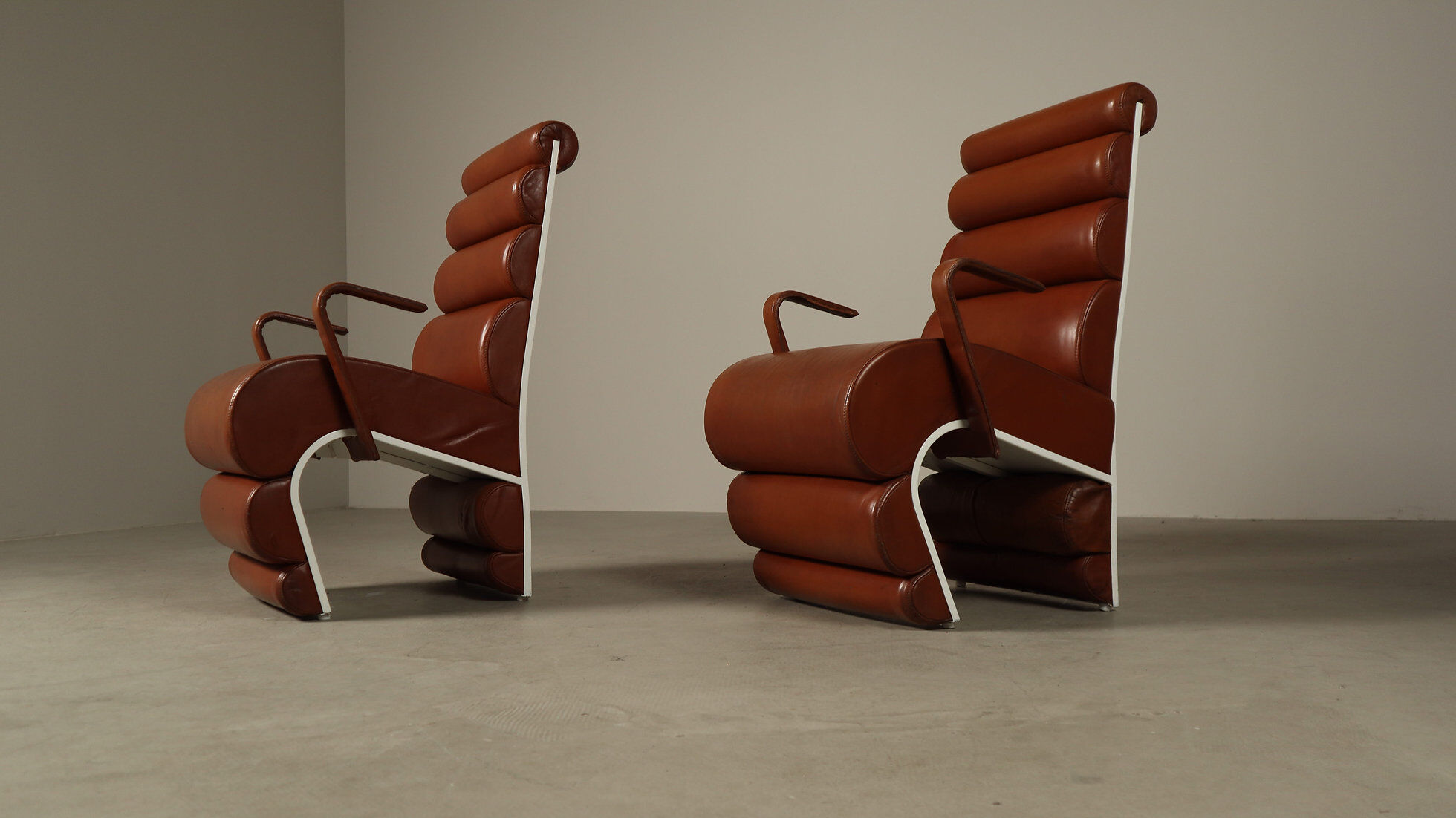 Pair of sculptural cognac leather armchairs, 1970s