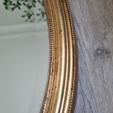 Oval mirror beveled gilded, wooden frame and stucco