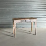Vintage table made of raw wood with a distressed white base.