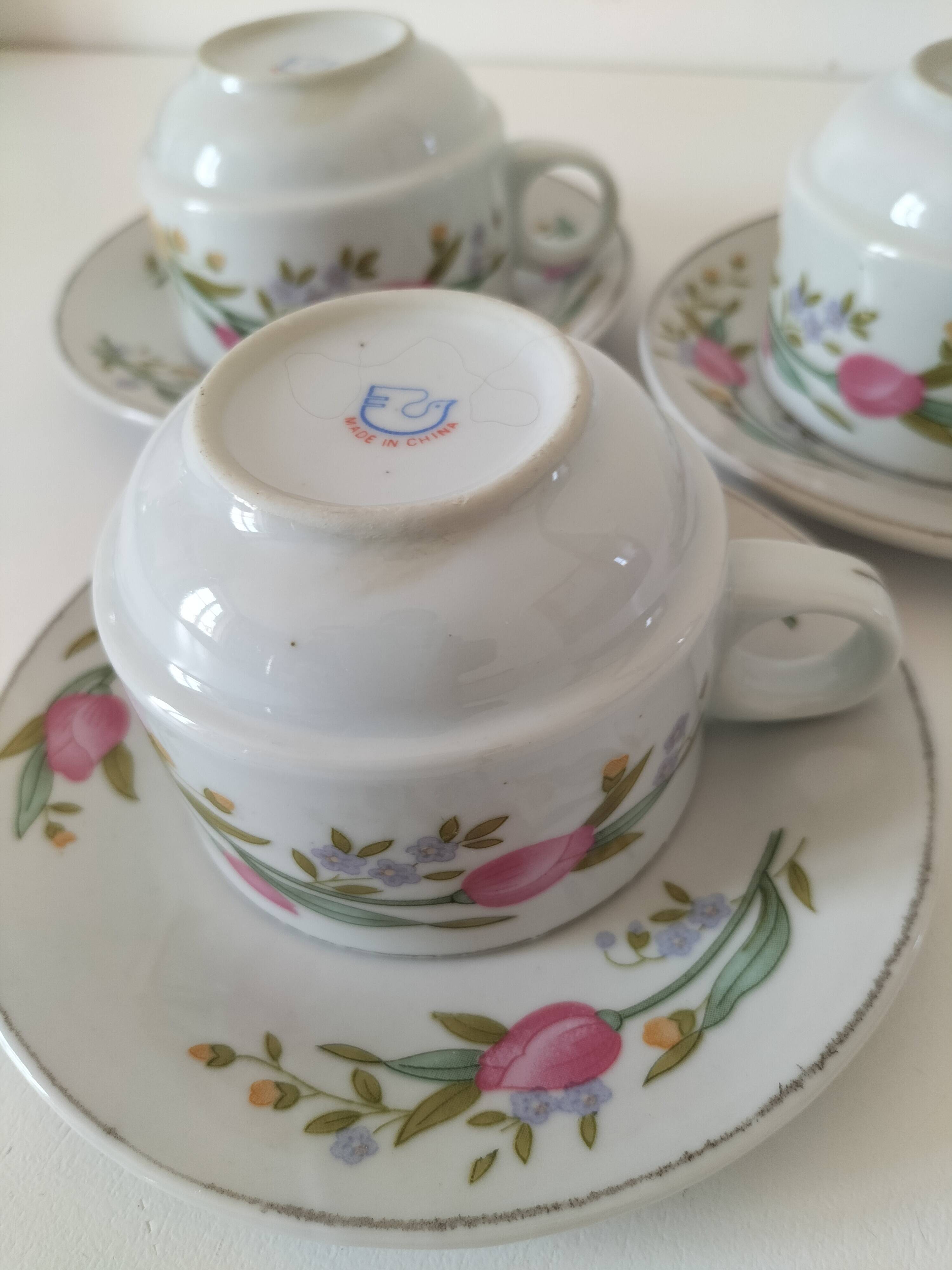 Trio of floral porcelain cups and saucers