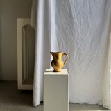 Large antique handmade ochre yellow jug with a pink flower pattern.