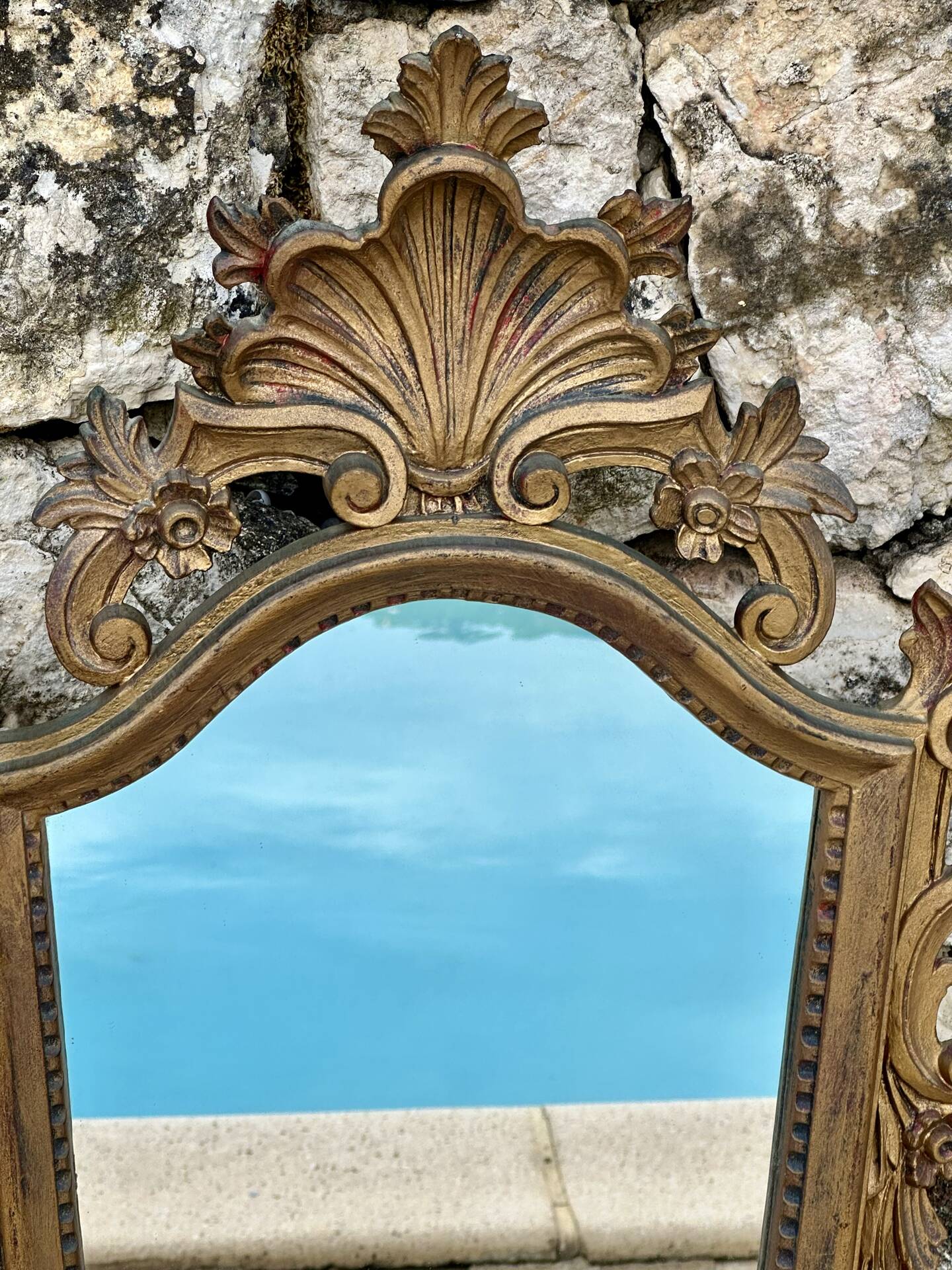 Carved and gilded wooden wall mirror.
