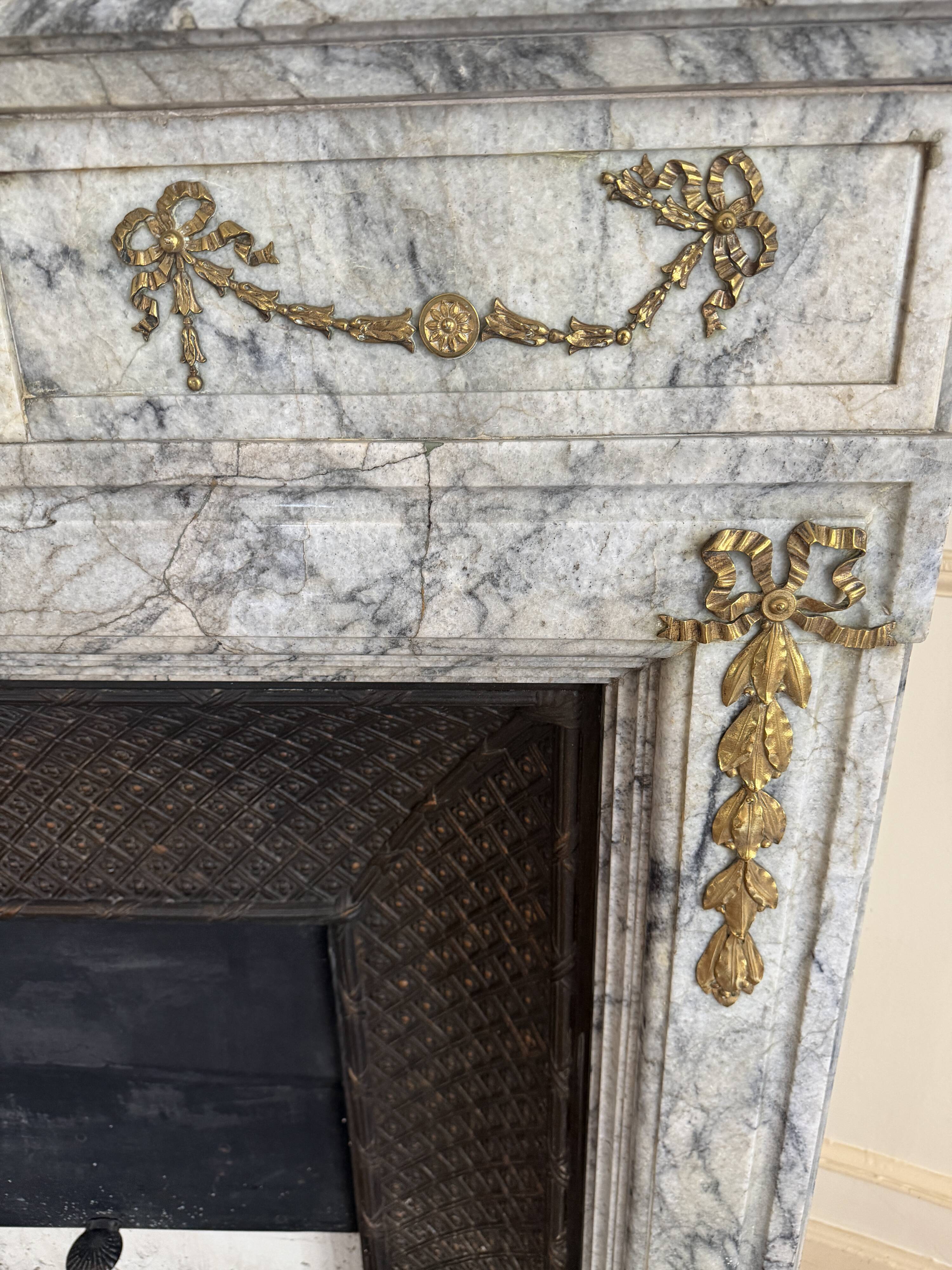 Louis XVI fireplace in veined grey marble with original gilded bronzes from the 19th century.