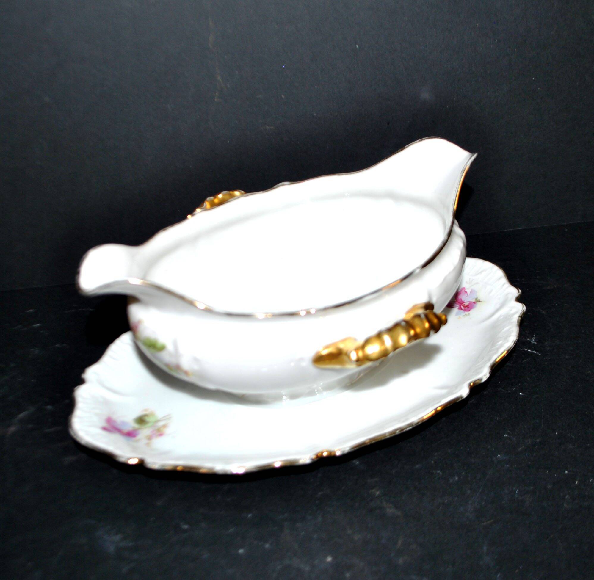 Vintage pouring sauce boat in floral porcelain with gilding.