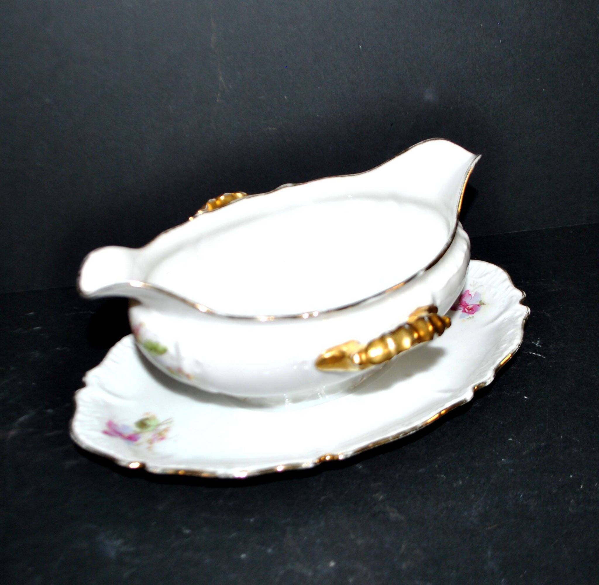Vintage pouring sauce boat in floral porcelain with gilding.