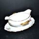 Vintage pouring sauce boat in floral porcelain with gilding.