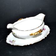 Vintage pouring sauce boat in floral porcelain with gilding.