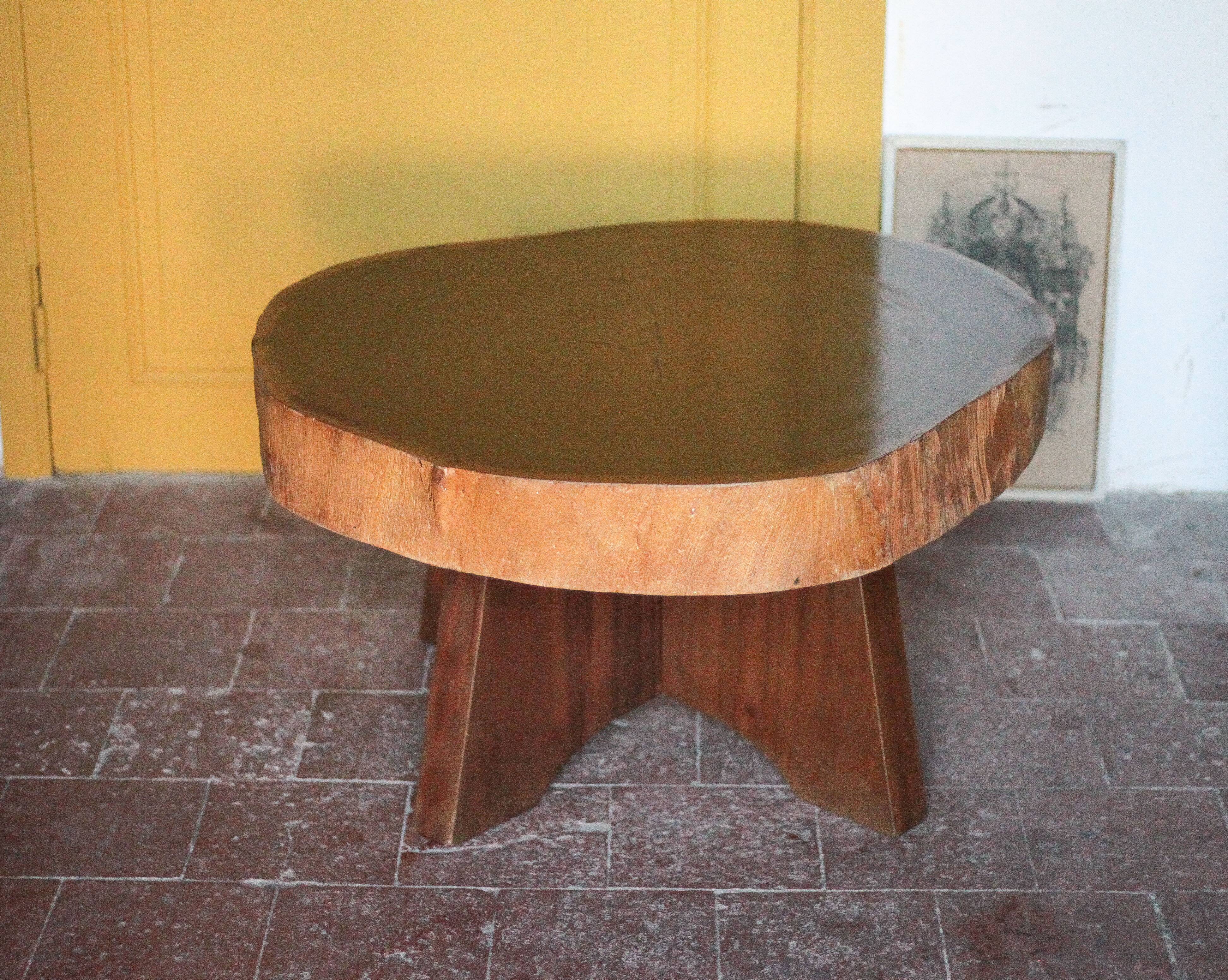 Brutalist wooden coffee table, cruciform leg with a tree trunk top.