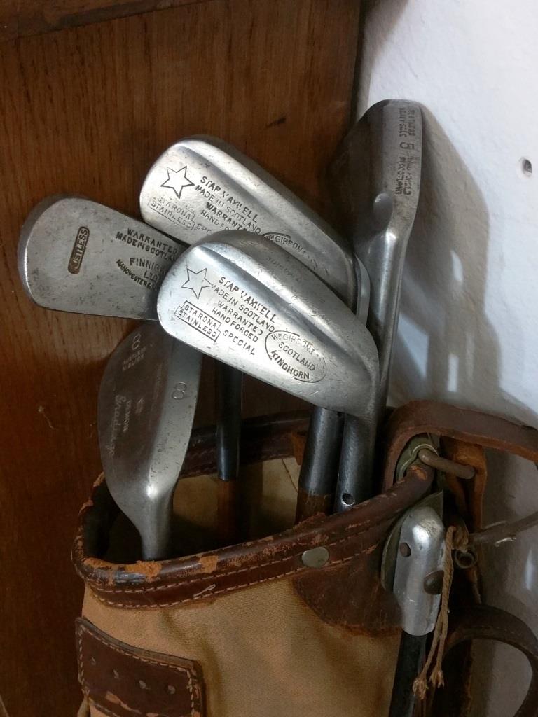 Old golf bag with 5 golf clubs