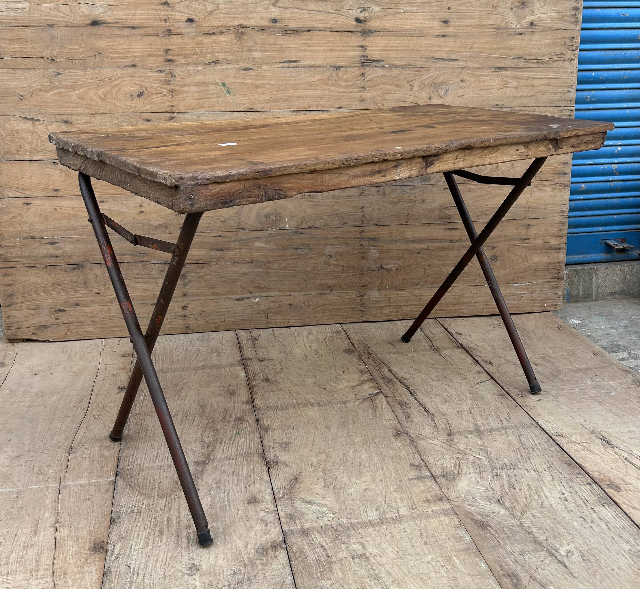Folding workshop table with a metal frame and solid teak top.