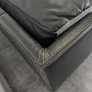 Black leather convertible sofa with goose feather upholstery.
