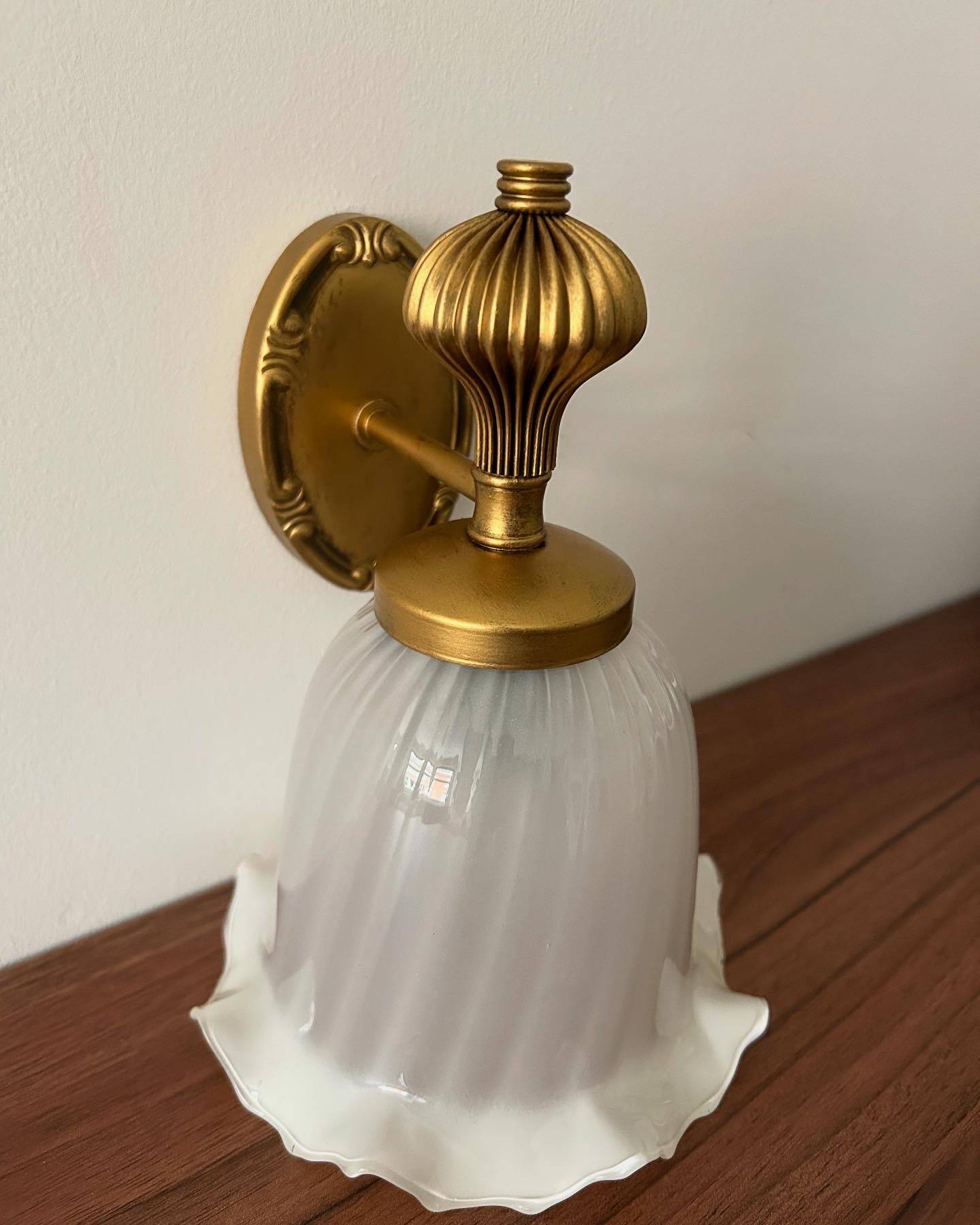 Gold wall sconce with ecru globe