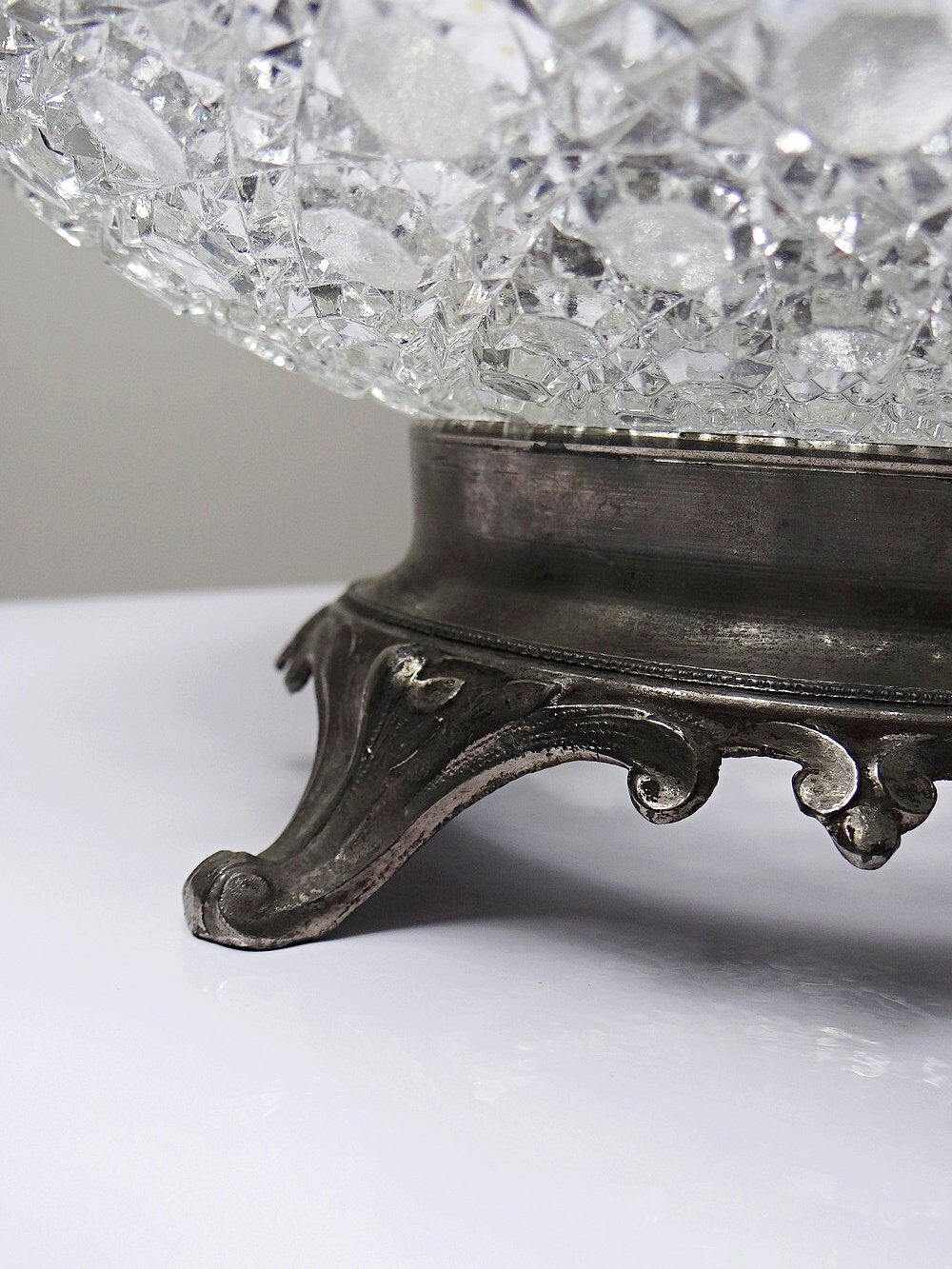 Pressed glass coupe with diamond points, antique from 1920-1950 on a pewter base.