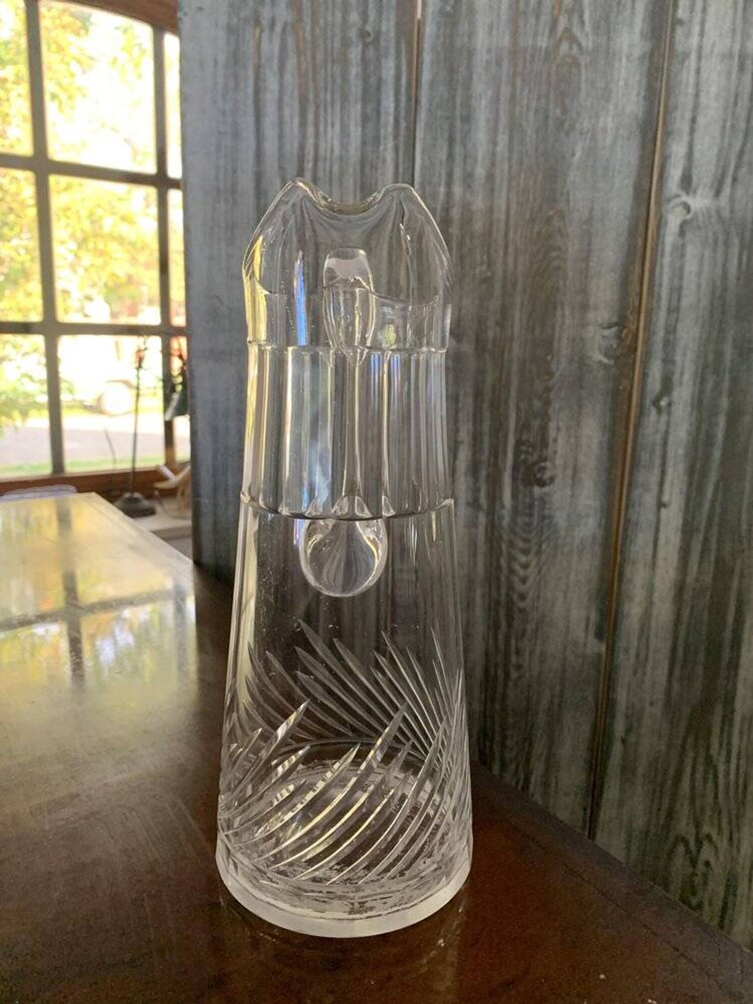 Transparent crystal pitcher, mid-century Hungarian, conical silhouette, sculptural handle and cut decoration.