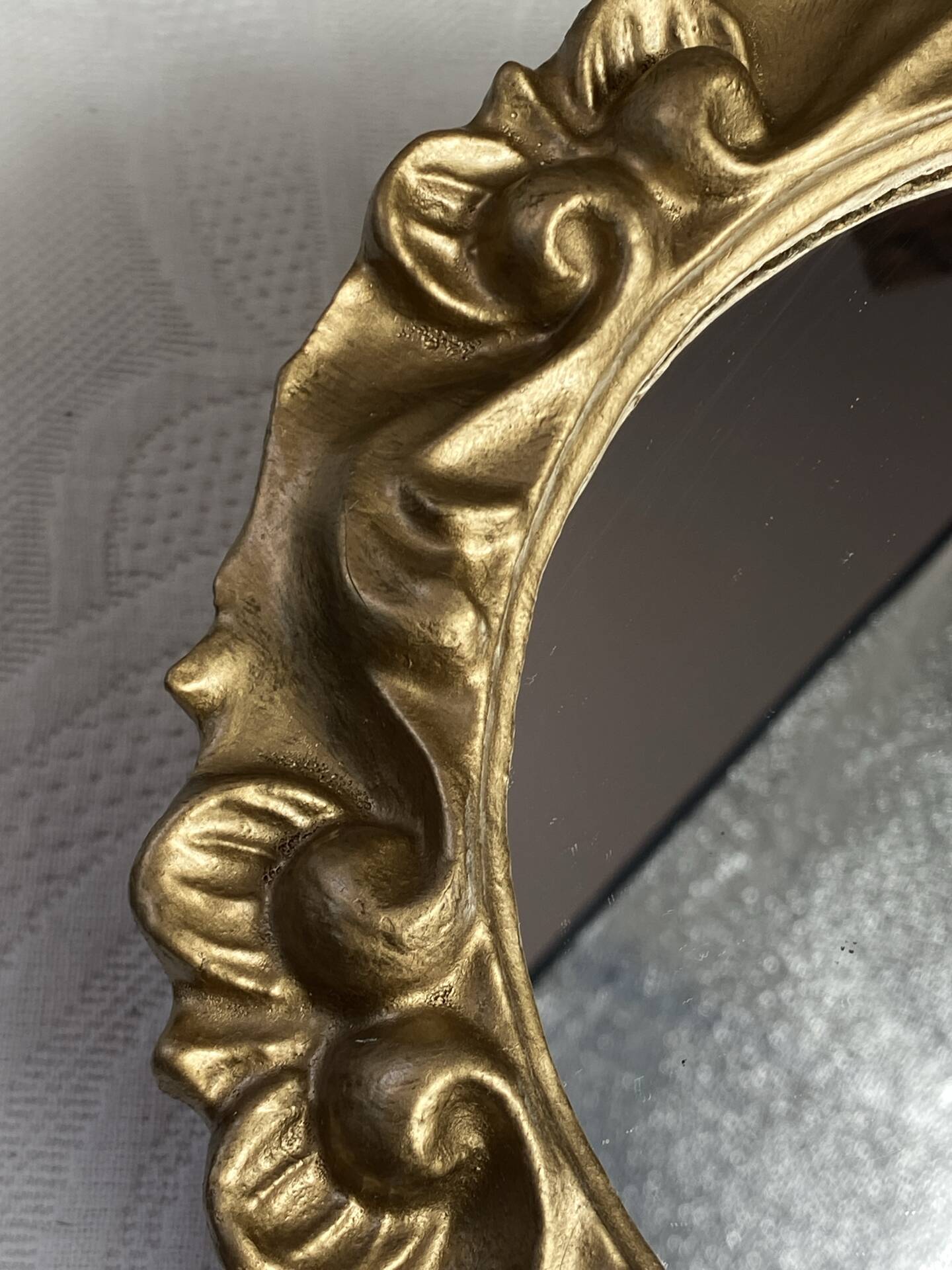 Round wooden mirror in golden colour.