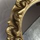 Round wooden mirror in golden colour.