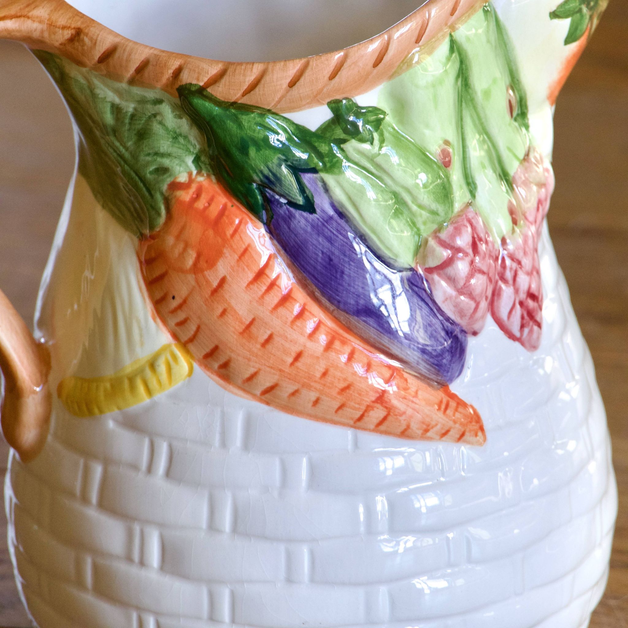 Hand-painted earthenware carafe with a raised vegetable basket design