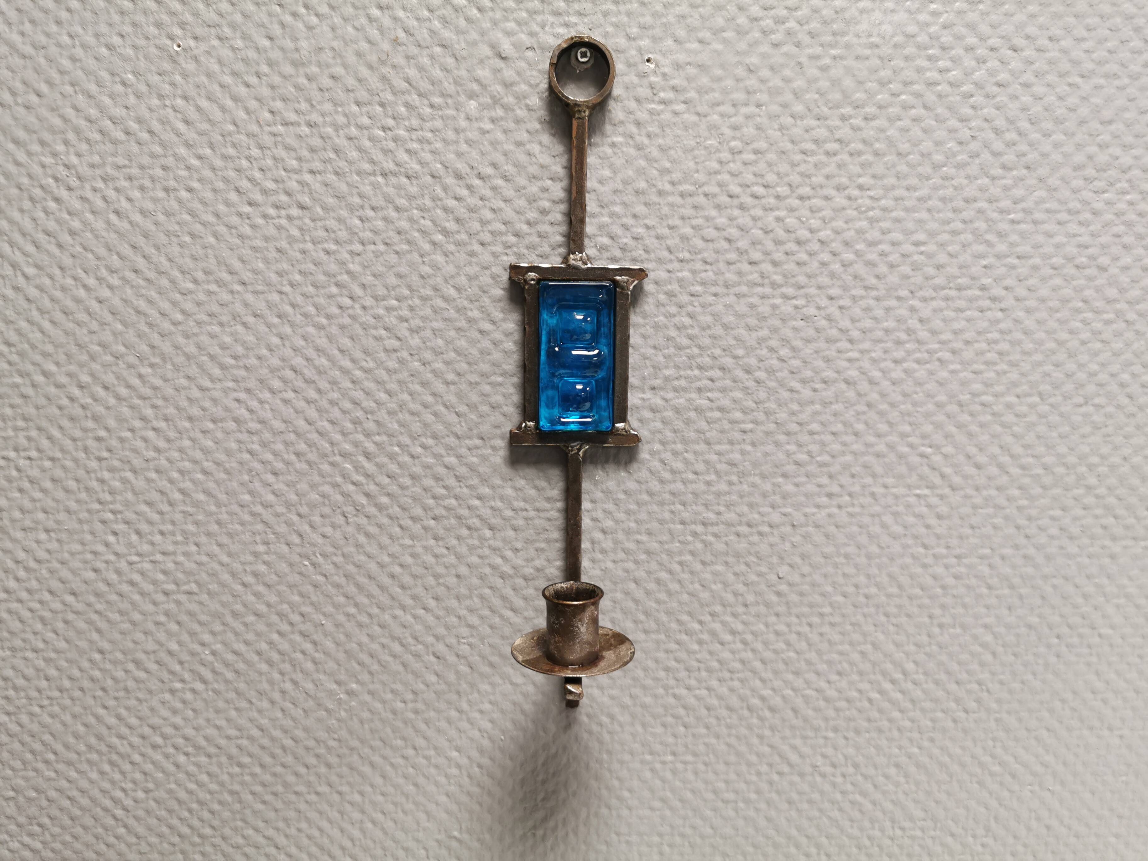 Wall-mounted candle holder in cast iron and hard pressed blue glass.