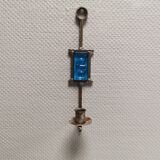 Wall-mounted candle holder in cast iron and hard pressed blue glass.