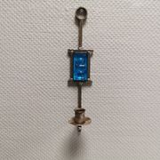 Wall-mounted candle holder in cast iron and hard pressed blue glass.