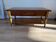 Vintage wooden coffee table with drawer and shelves.