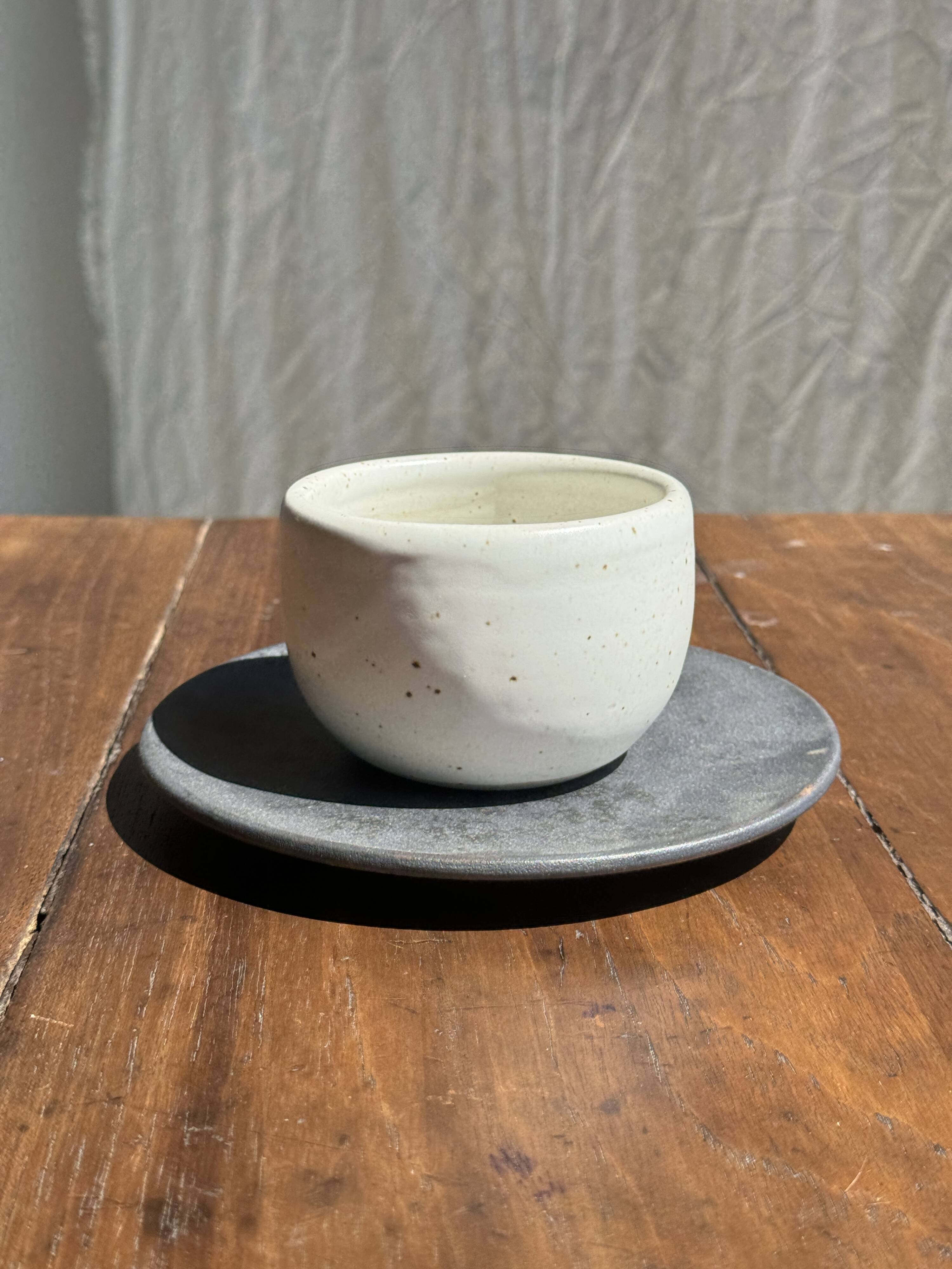 White Indonesian ceramic cup and gray saucer