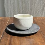 White Indonesian ceramic cup and gray saucer