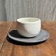 White Indonesian ceramic cup and gray saucer