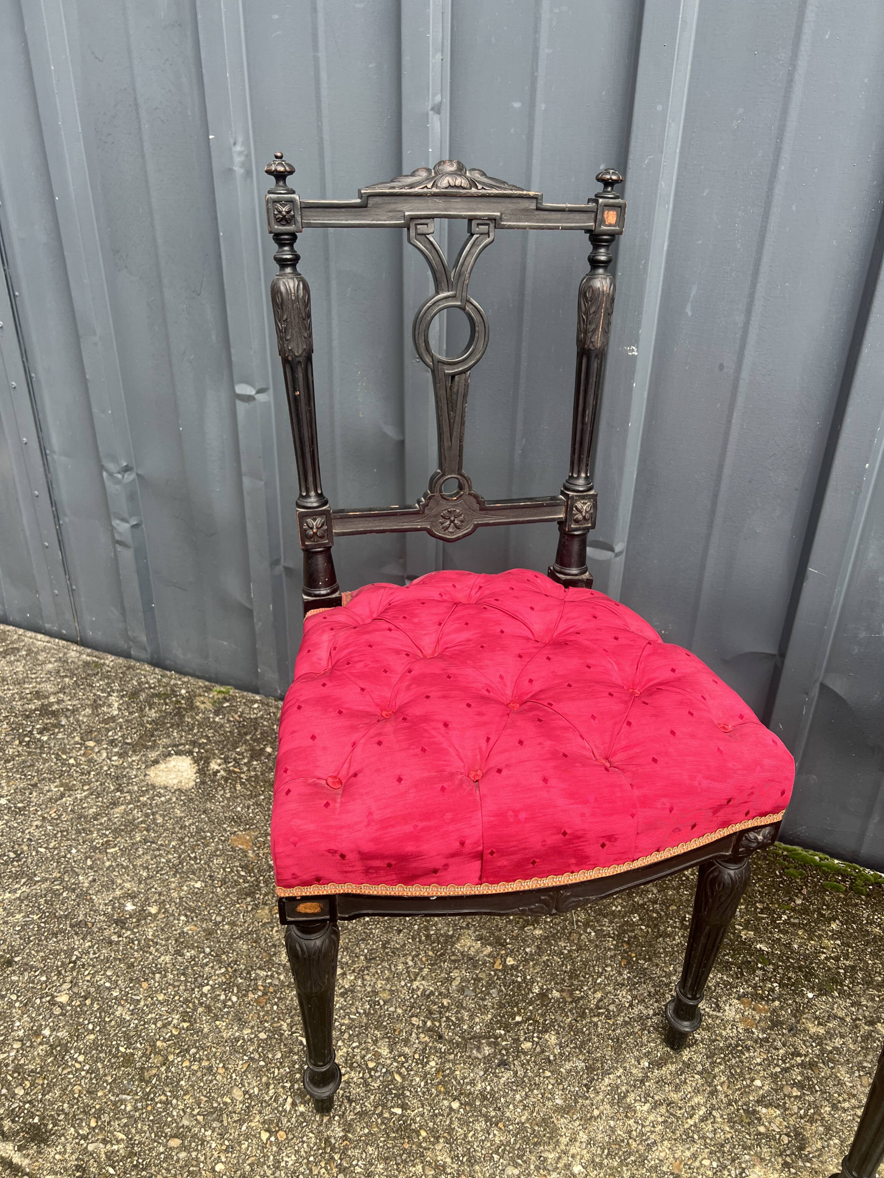 Pair of black lacquered chairs with purple tufted upholstery.