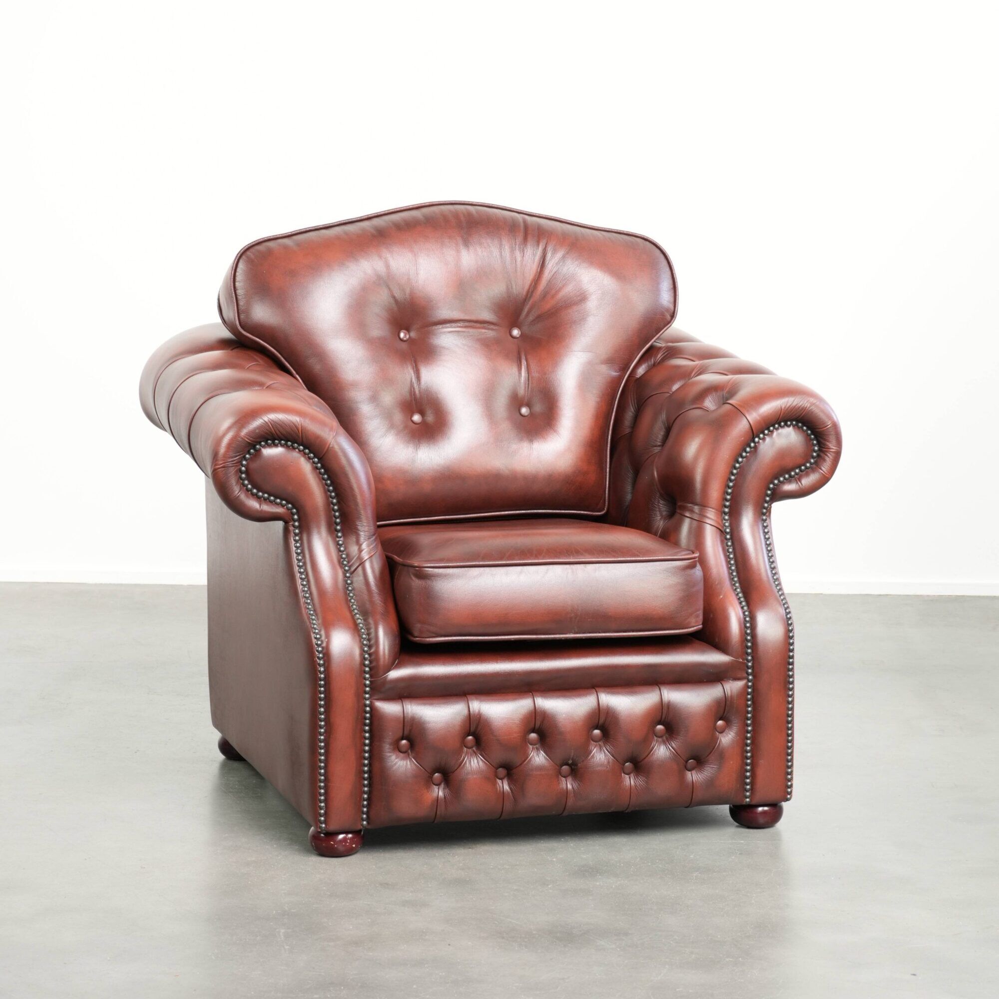 Cowhide chesterfield armchair in a warm brown colour with decorative nails