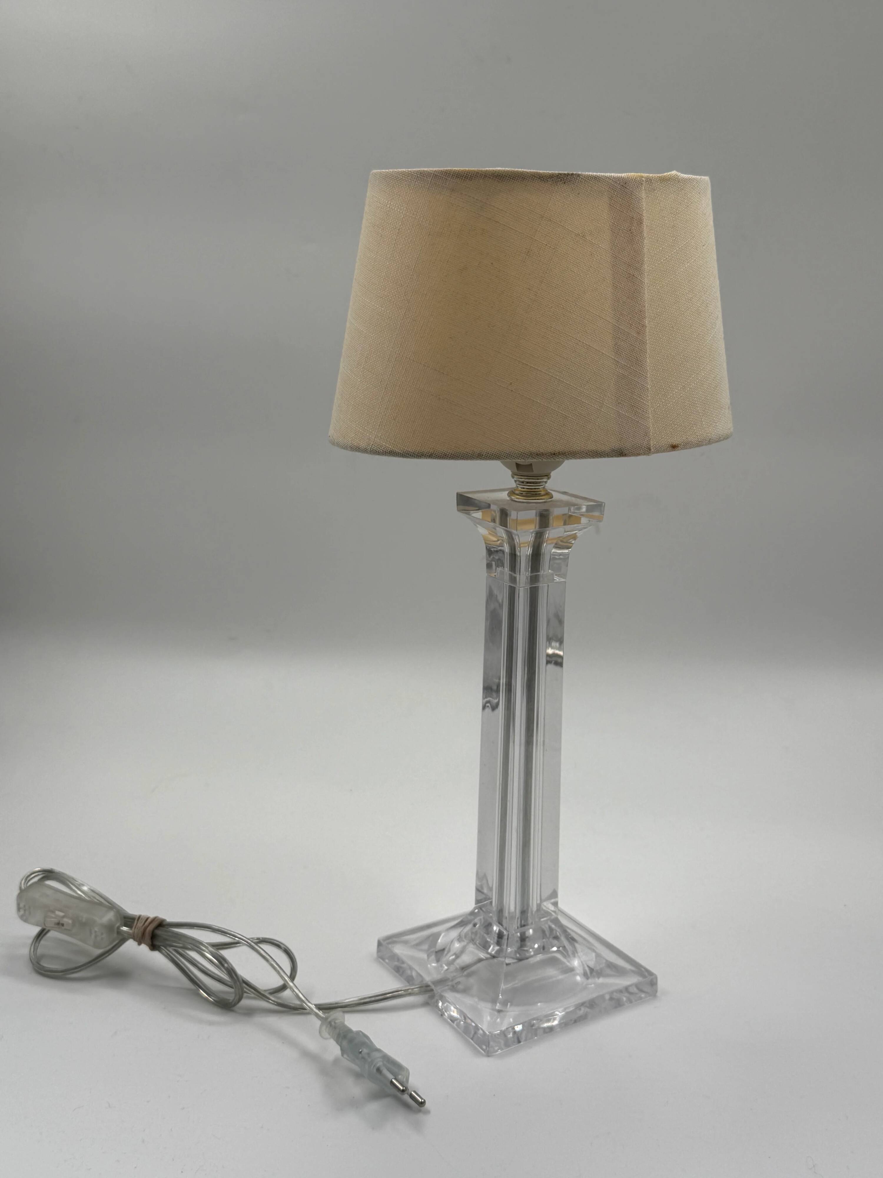 Modern table lamp in plexiglass with fabric shade.