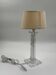 Modern table lamp in plexiglass with fabric shade.