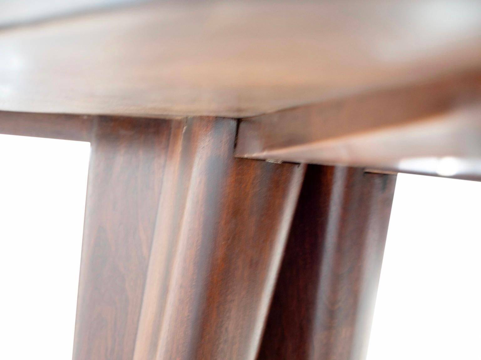 Dining table with a wooden frame and tinted glass top.