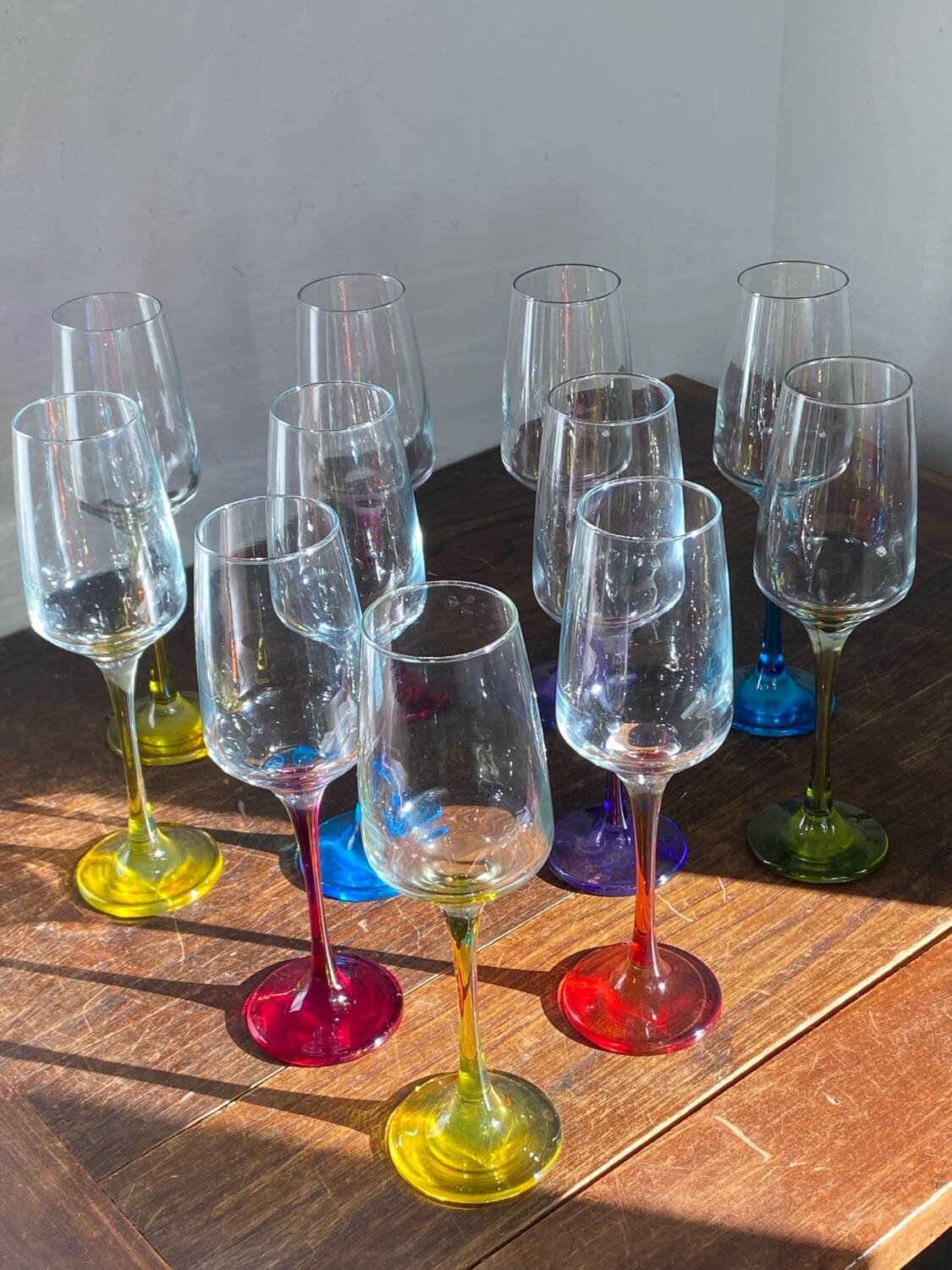 Champagne coupes in glass, multicoloured stems.