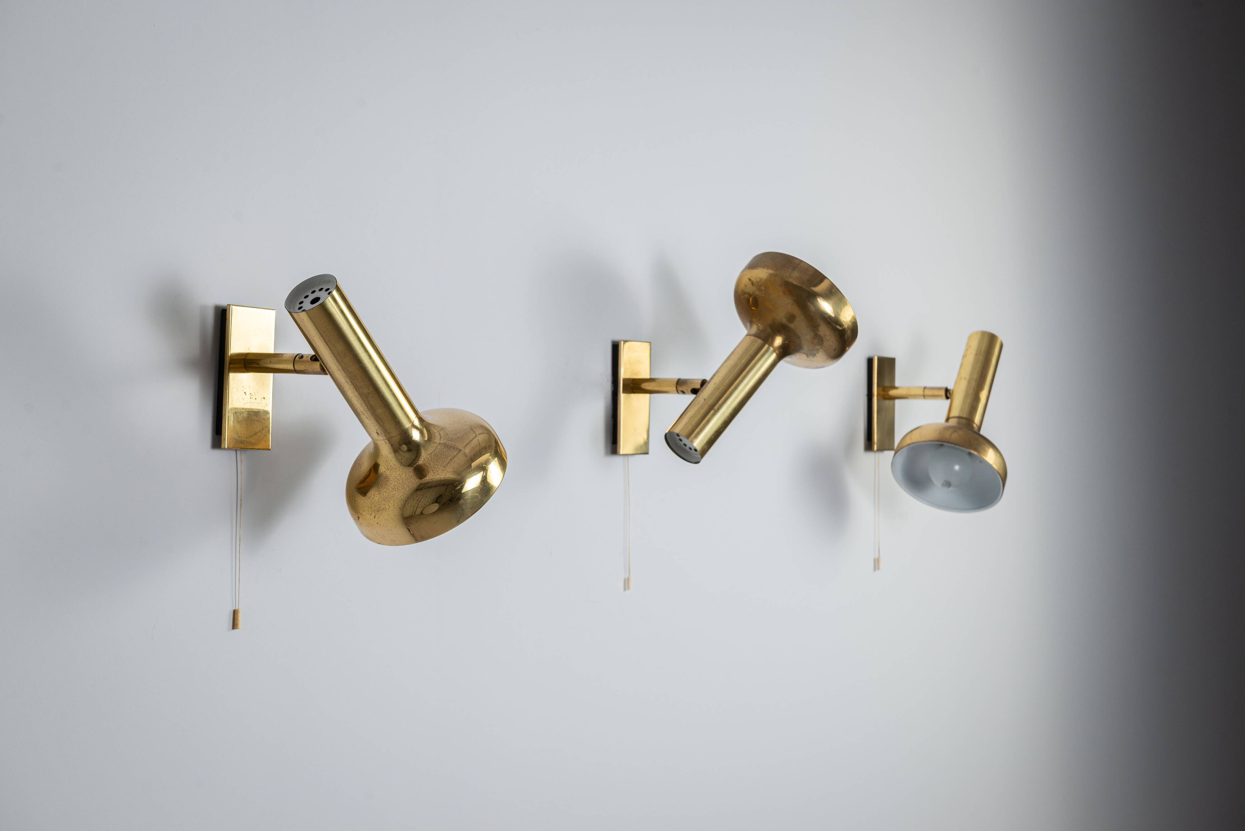 Set of three brass adjustable wall lamps