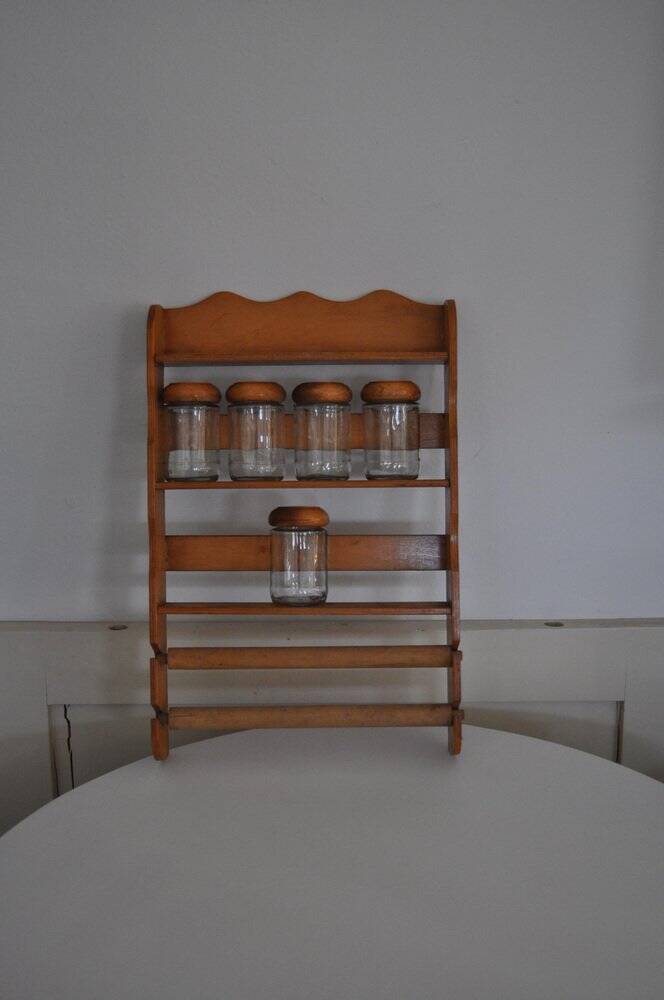Brown wooden wall spice rack with a set of 6 glass jars, 1950s vintage style.