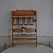 Brown wooden wall spice rack with a set of 6 glass jars, 1950s vintage style.