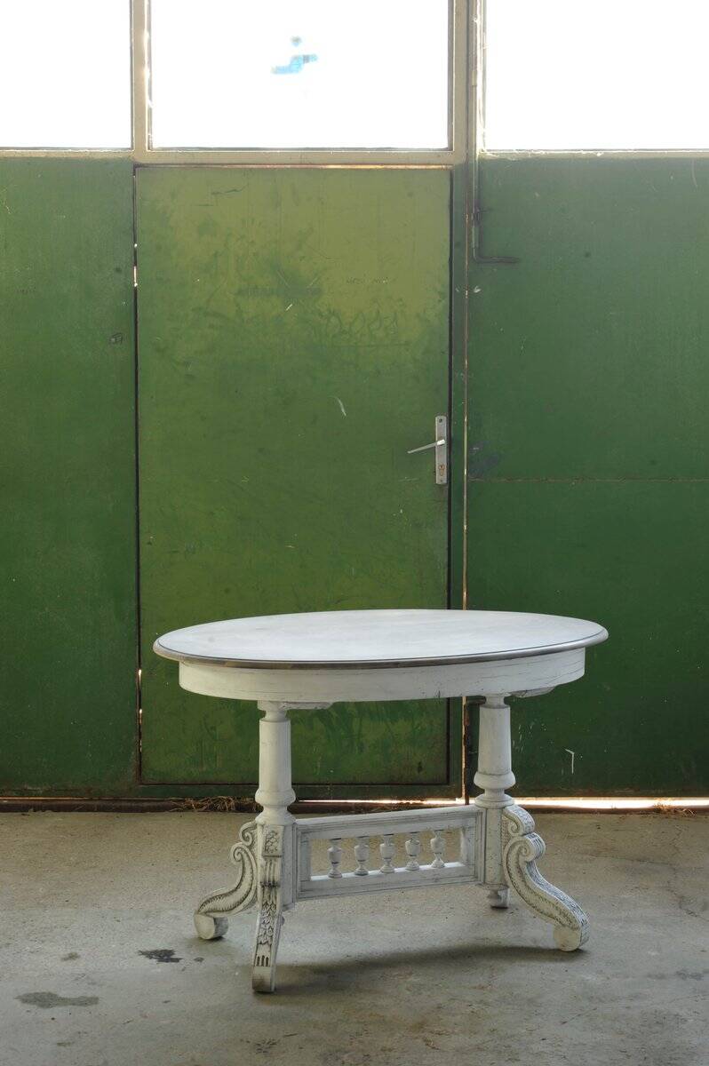Oval coffee table in carved wood, white patina, moulded edge, from the period 1890-1919.