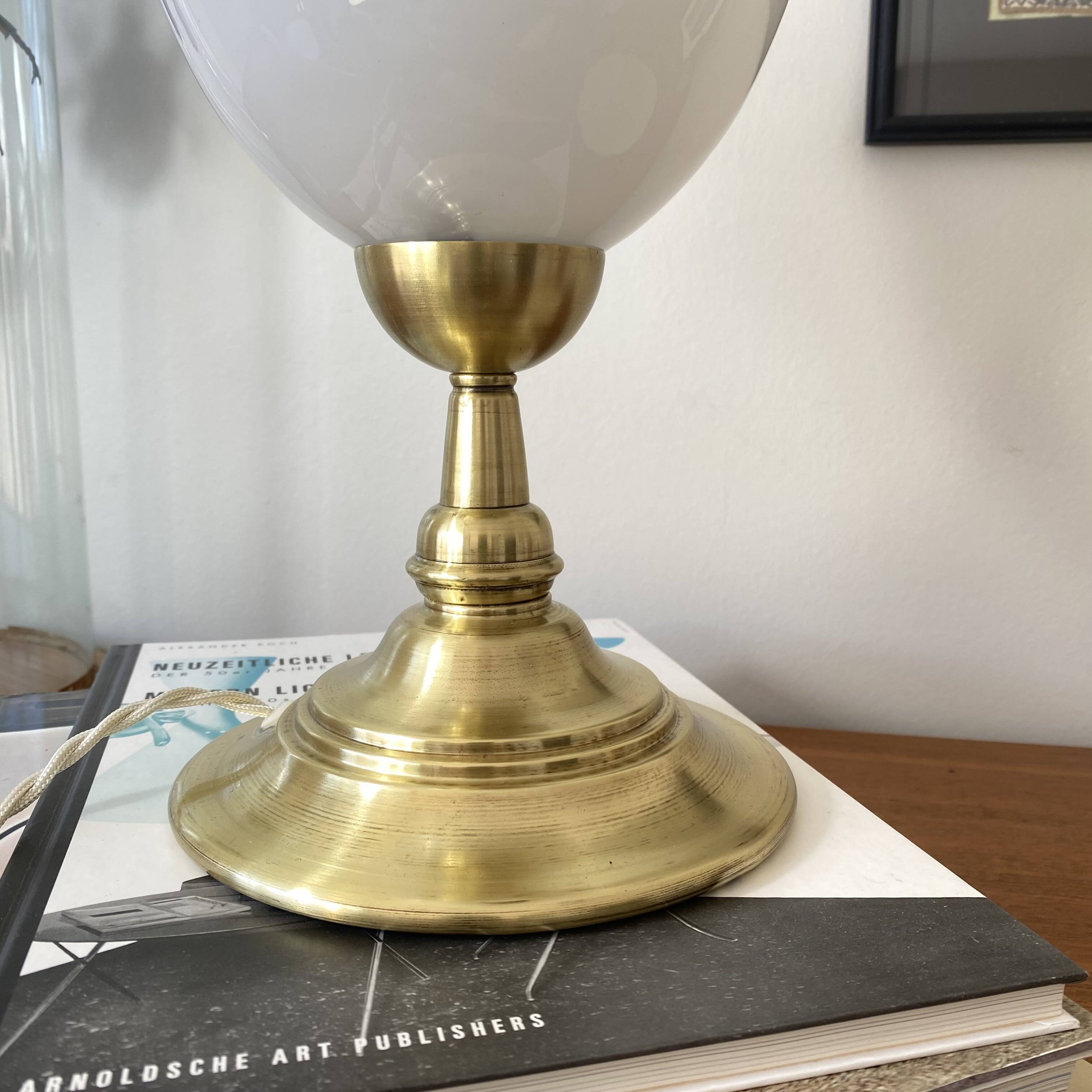 Antique white opaline glass globe table lamp with a brass base.