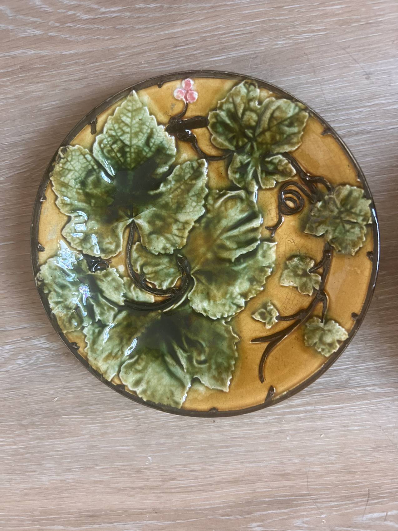 Four antique dessert plates in majolica with vine decoration.