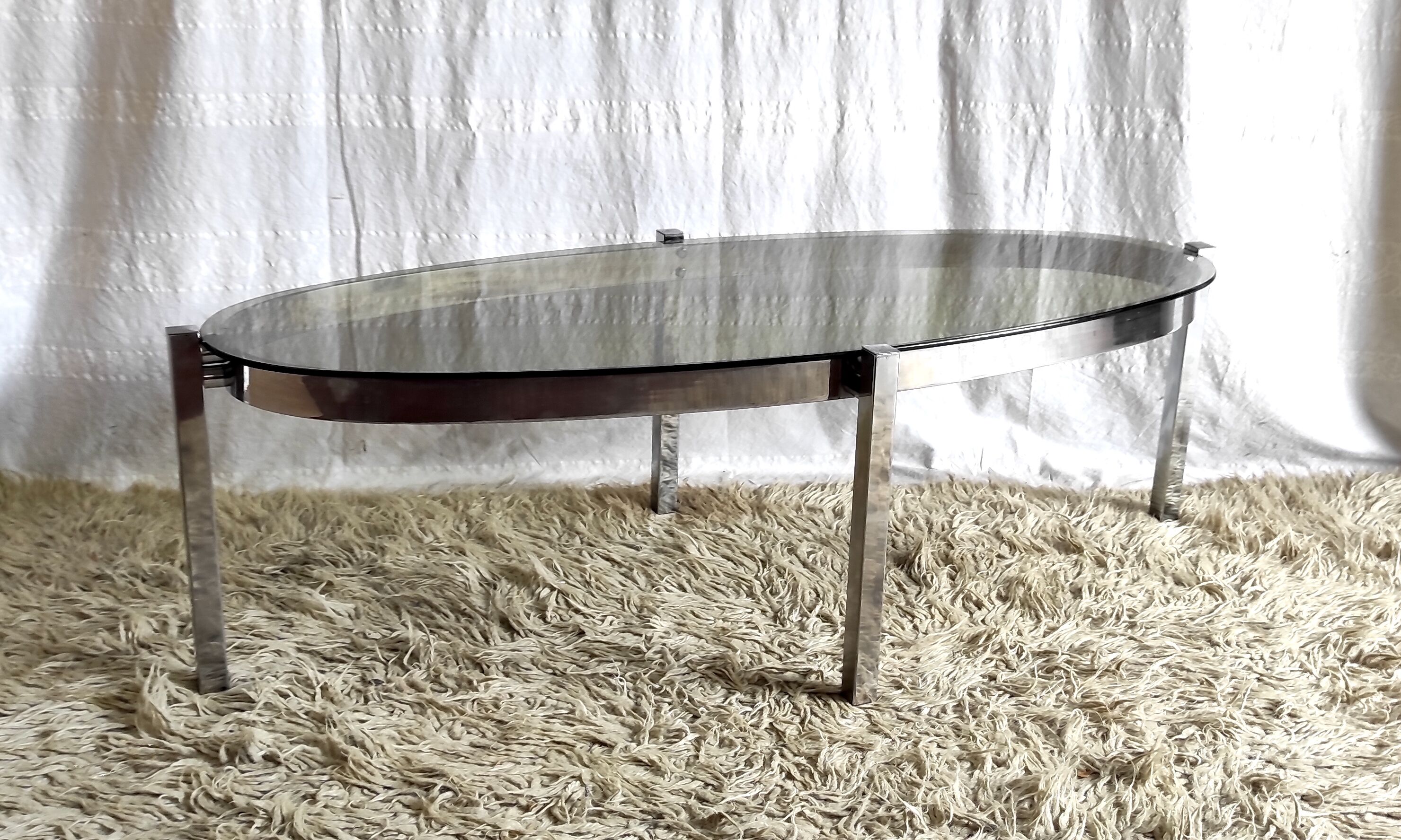 Table basse de forme élyptique en metal chomé et verre fumé, années 70