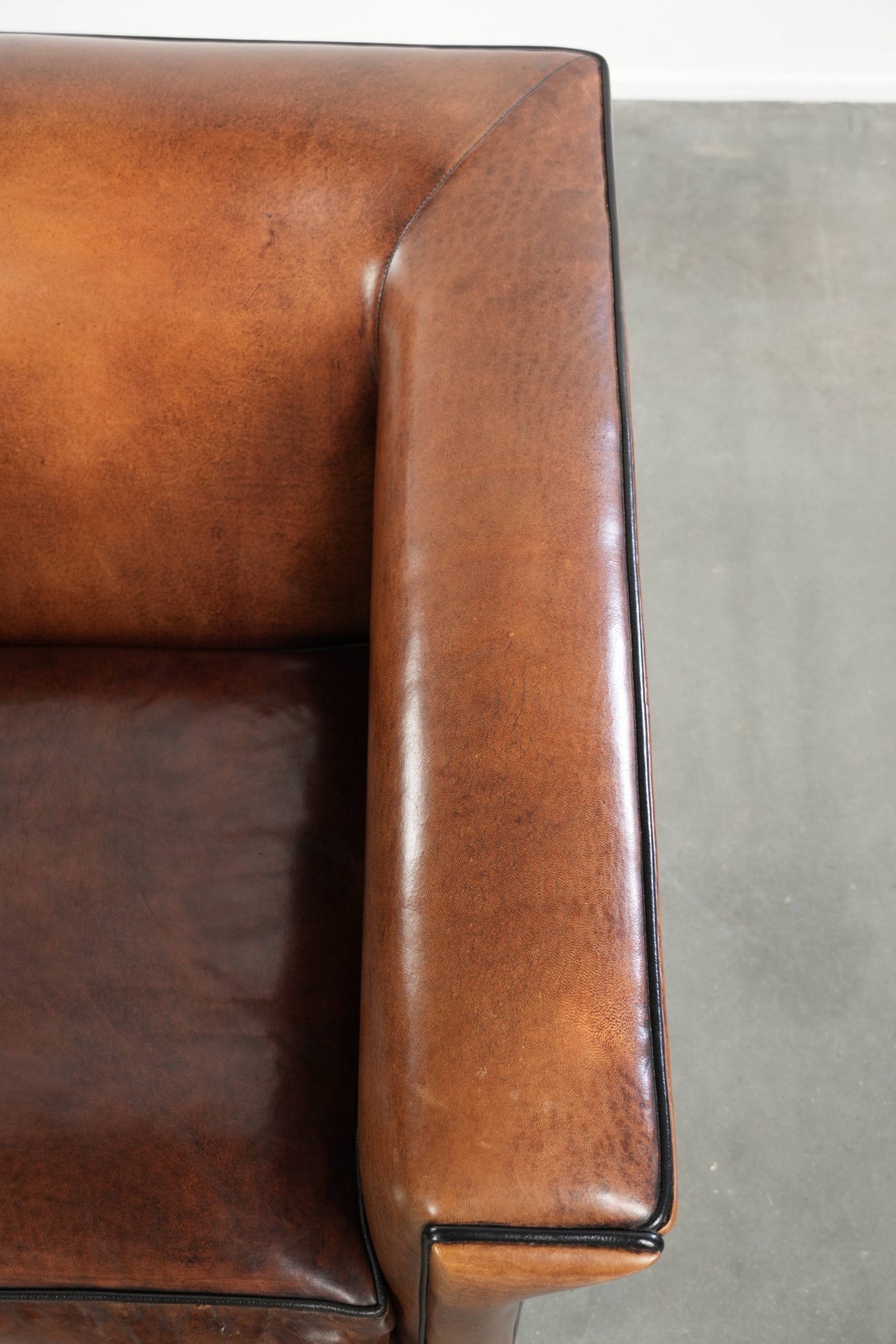 Sleek sheepskin Art Deco design armchair with black piping
