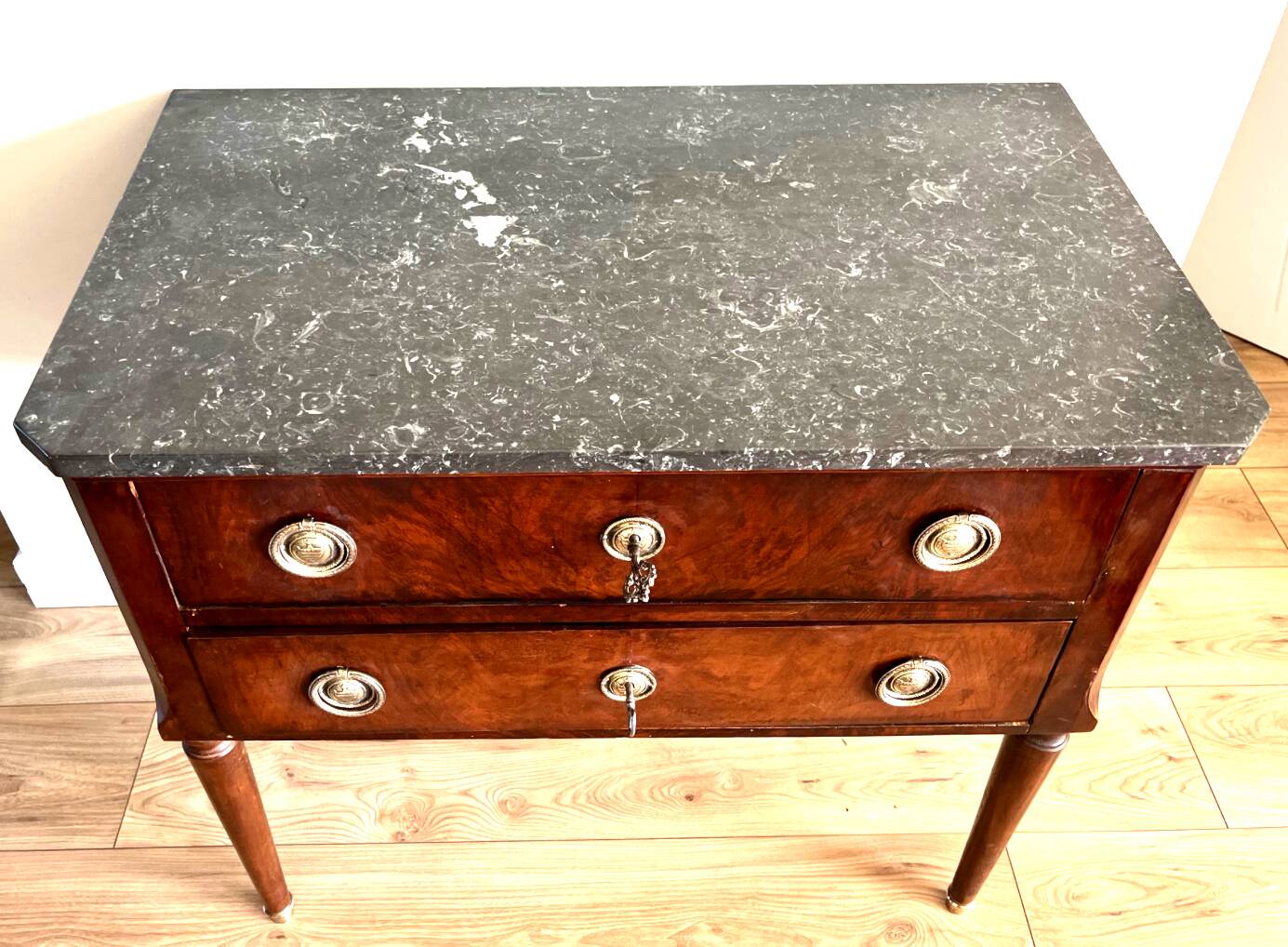 Louis XVI style wooden veneered chest of drawers with a marble top.