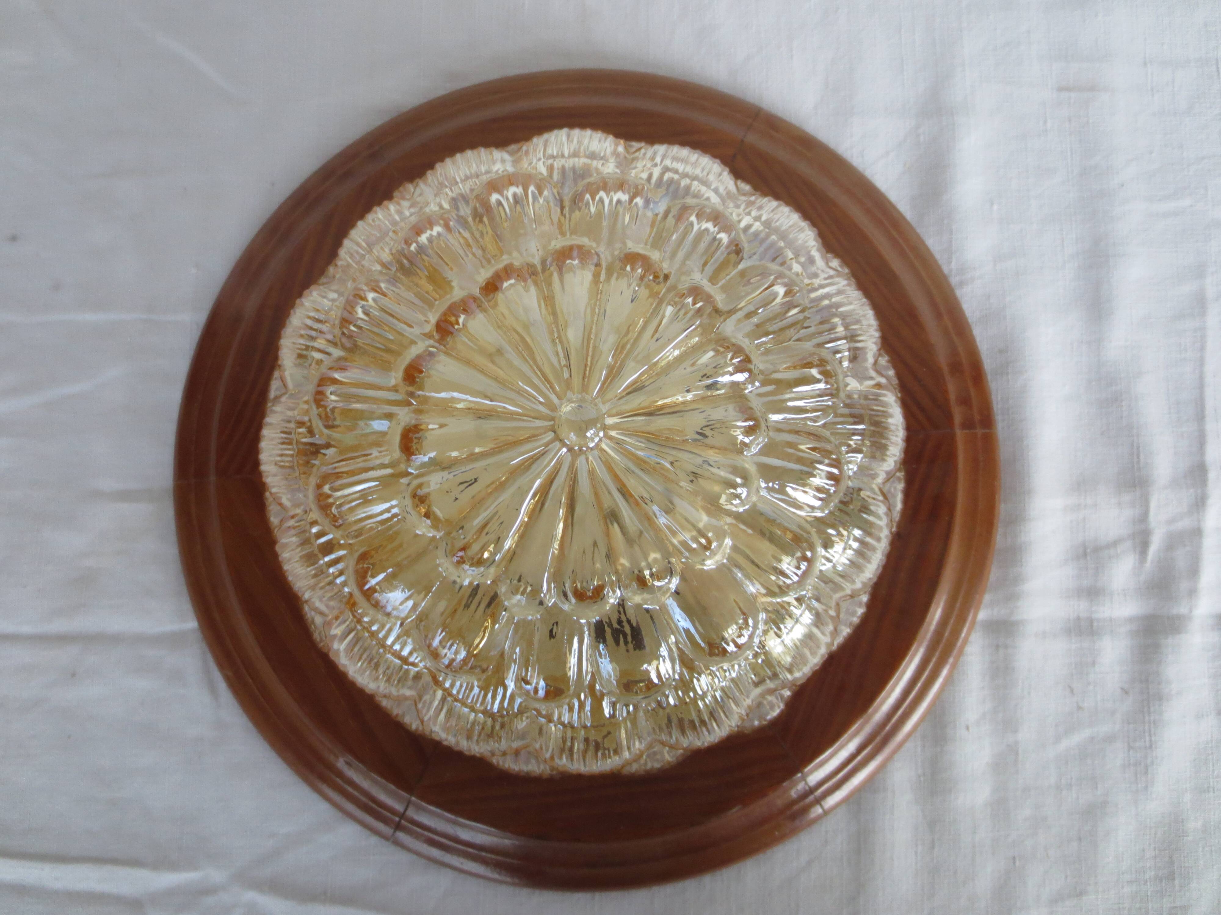 ceiling light with amber glass globe, on a round light wood base