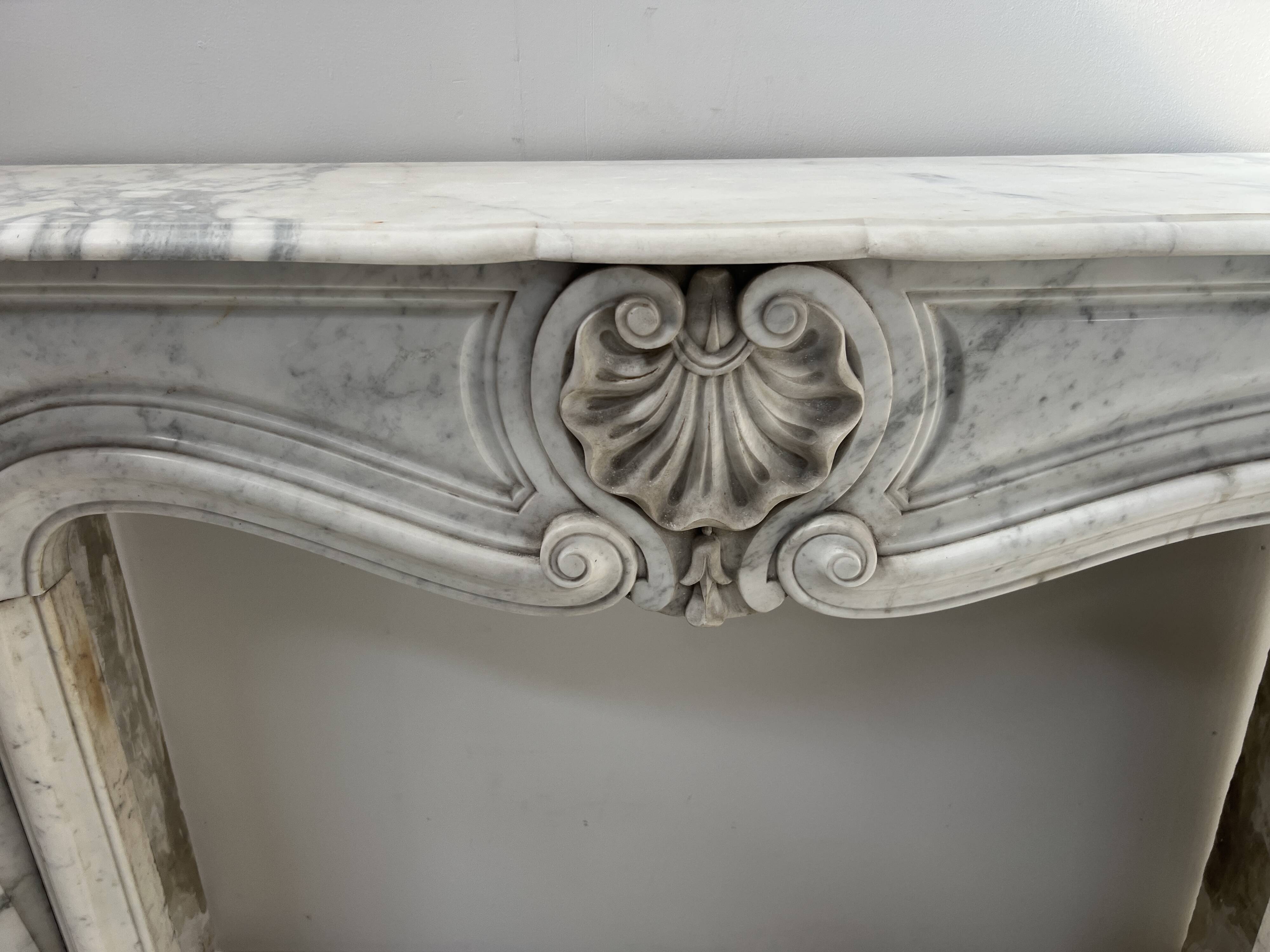 Louis XV style fireplace in veined white Carrara marble, 19th century.
